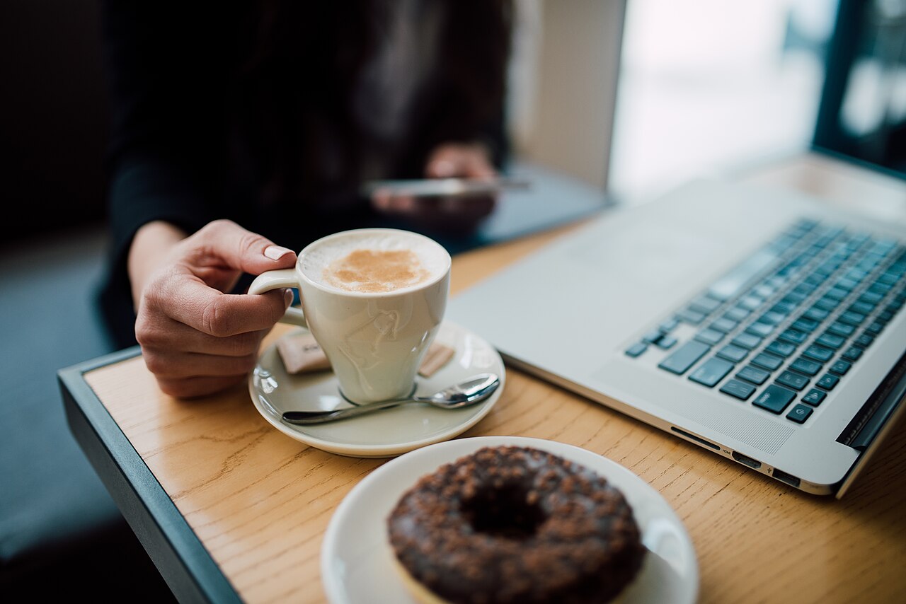 Close up of a woman using her smartphone while having coffee