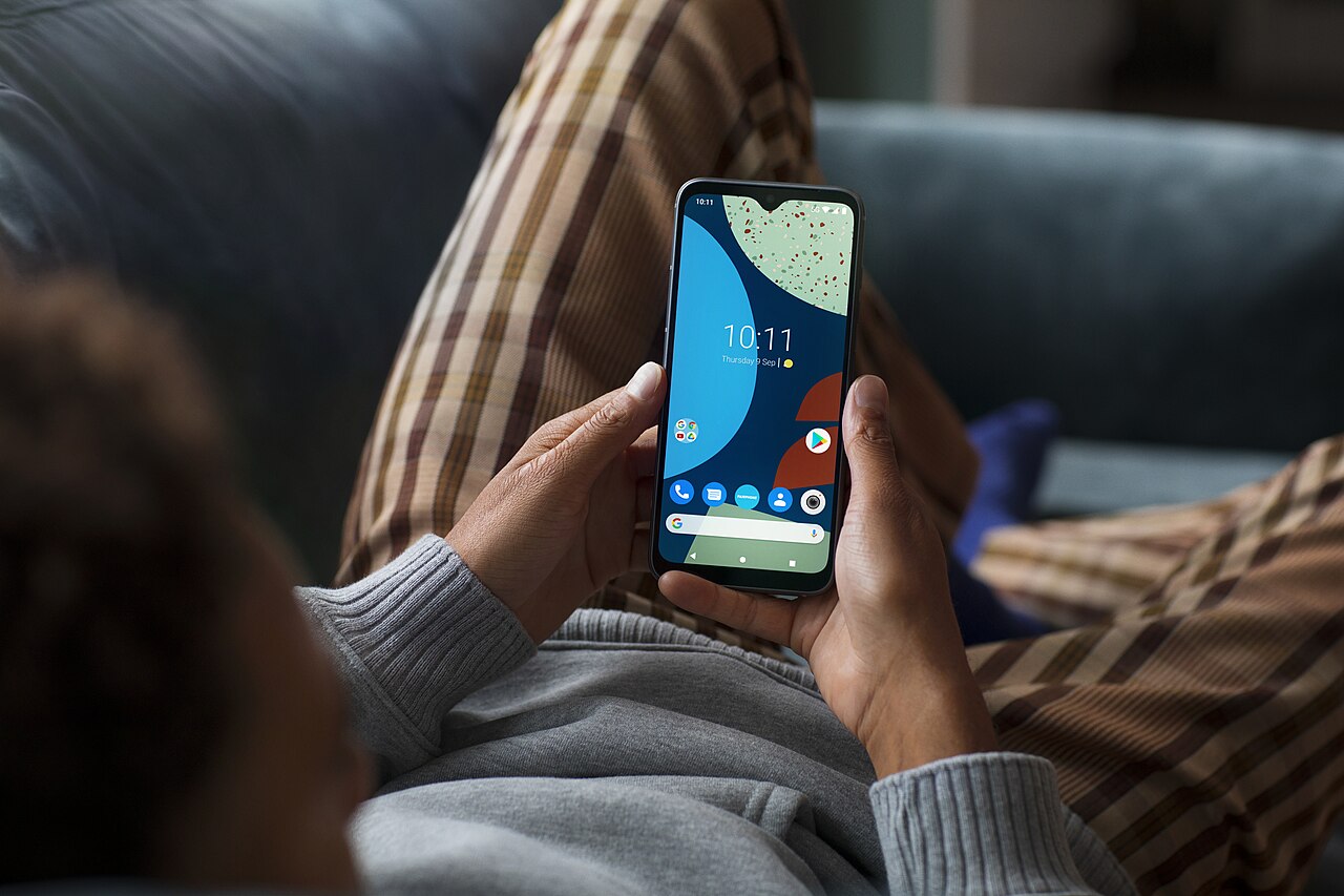 Fairphone 02 grey phone in hand on couch Kera 0091 C1 RGB
