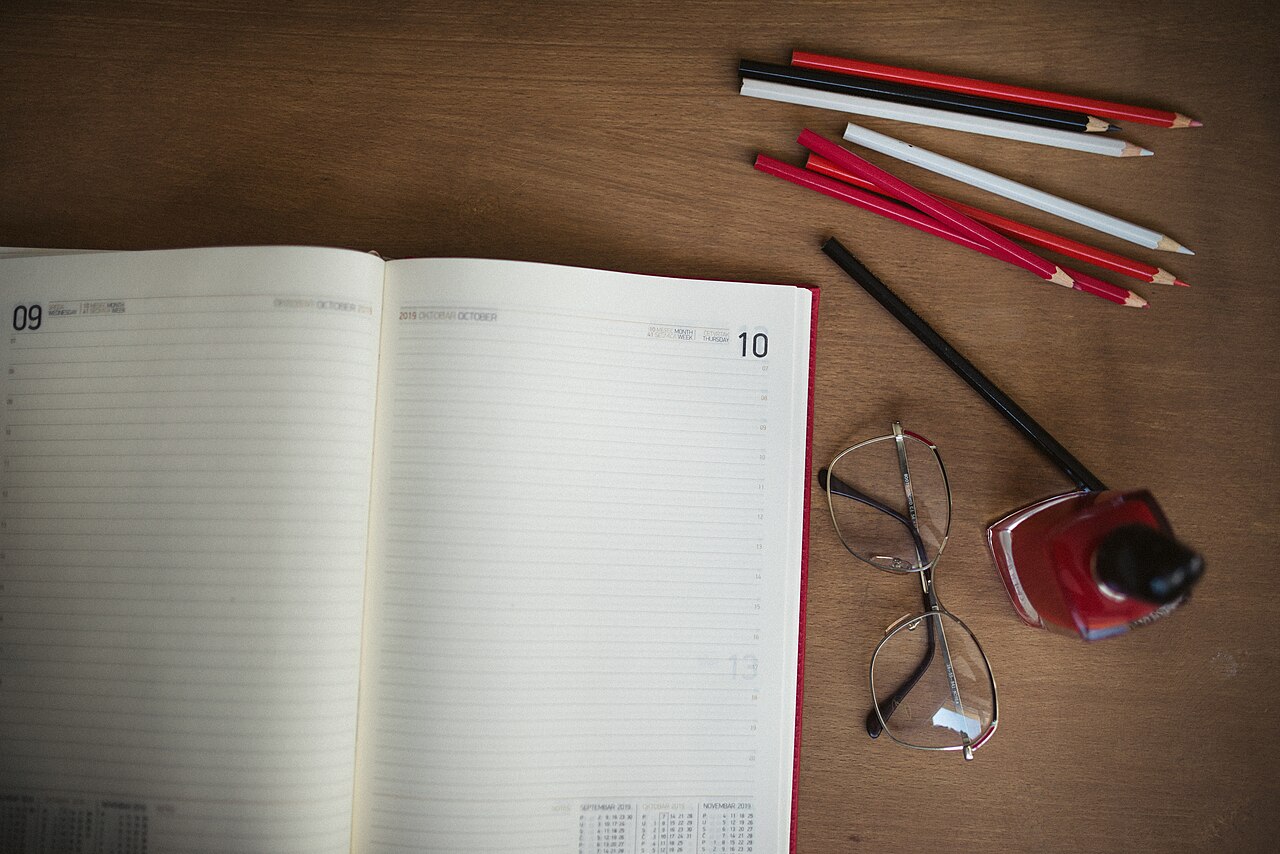 Working on a planning session with stationery items, notebook, and colorful pencils on a wooden desk