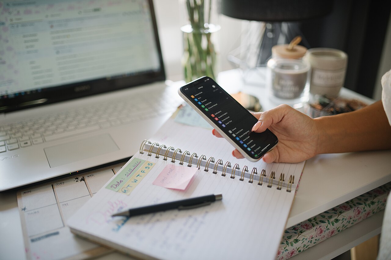 Young businesswoman holding her smartphone in the home office